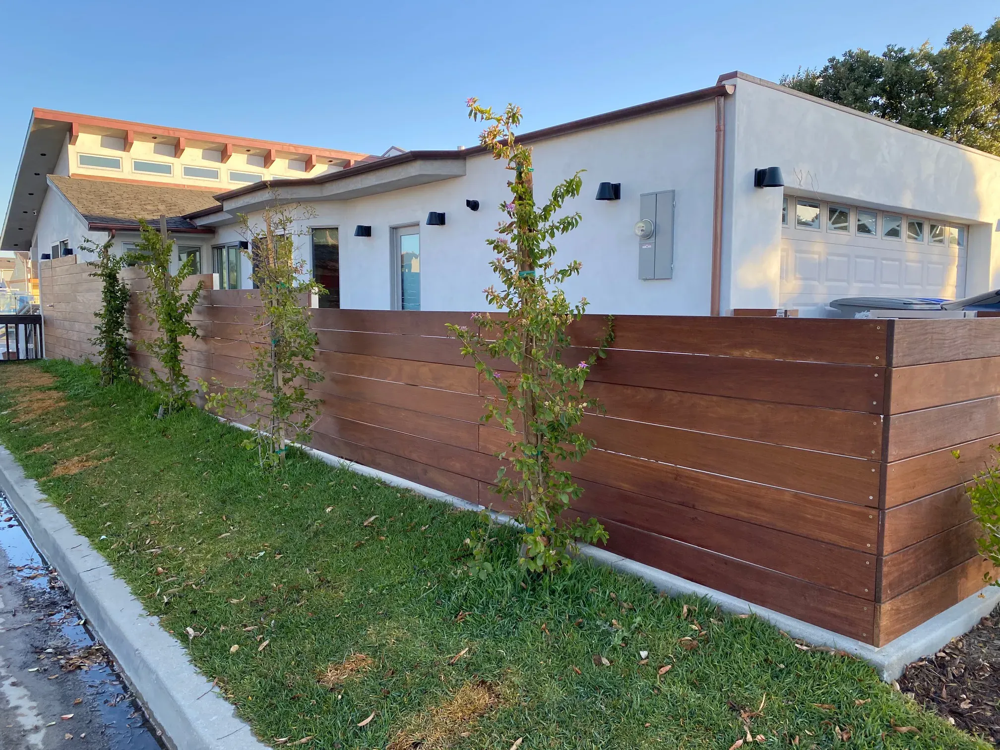 Street elevation of the Mandalay dock home with horizontal wood fence