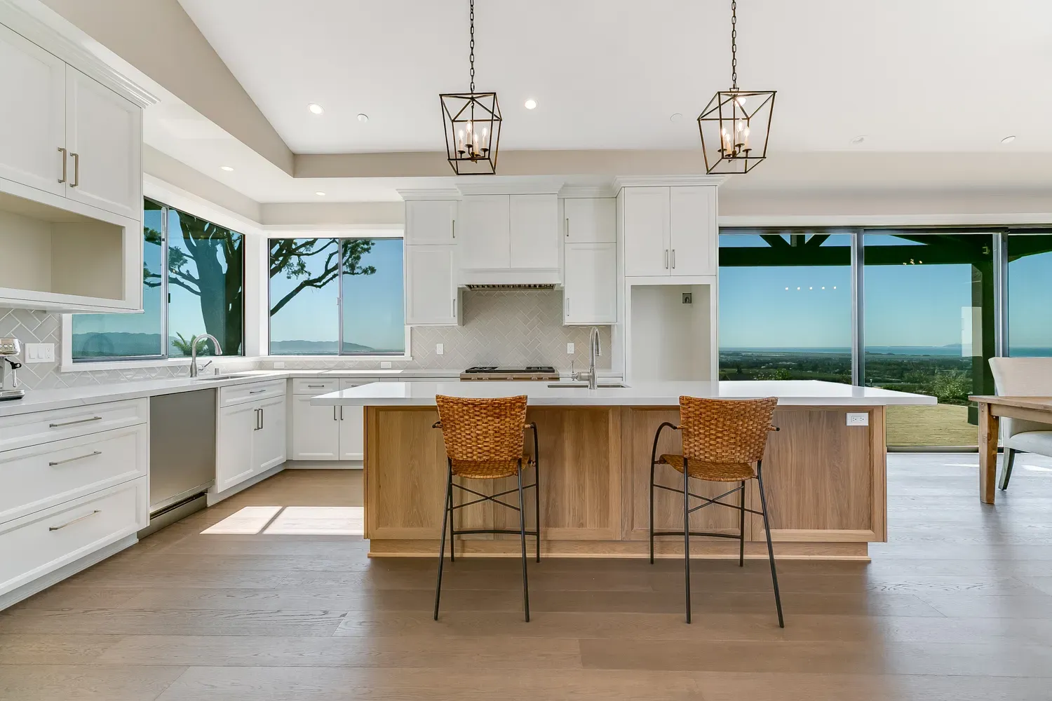 White kitchen with island and lantern pendants in the Mesa Circle home