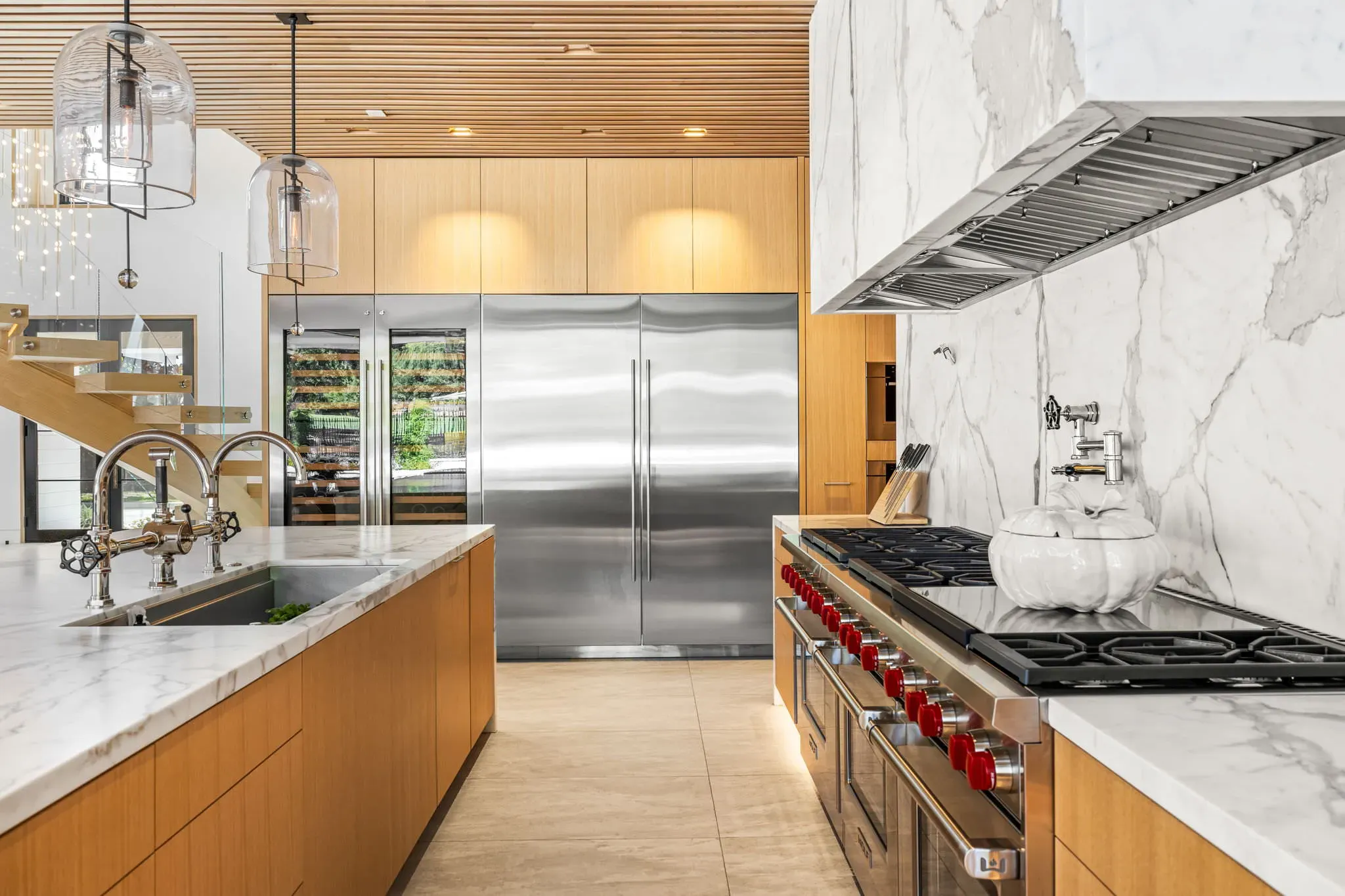 Custom kitchen with bookmatched marble backsplash and professional range, North Ranch