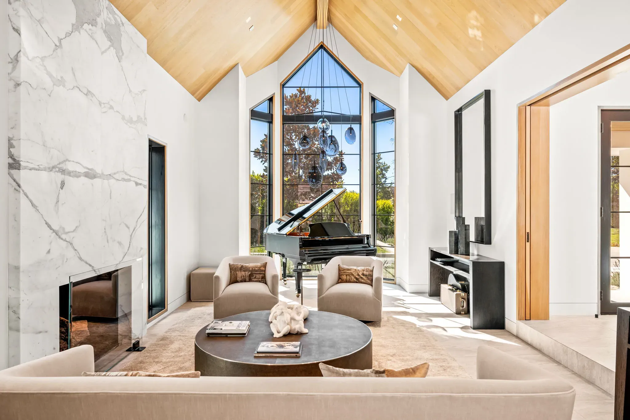 Vaulted formal living room with marble fireplace wall