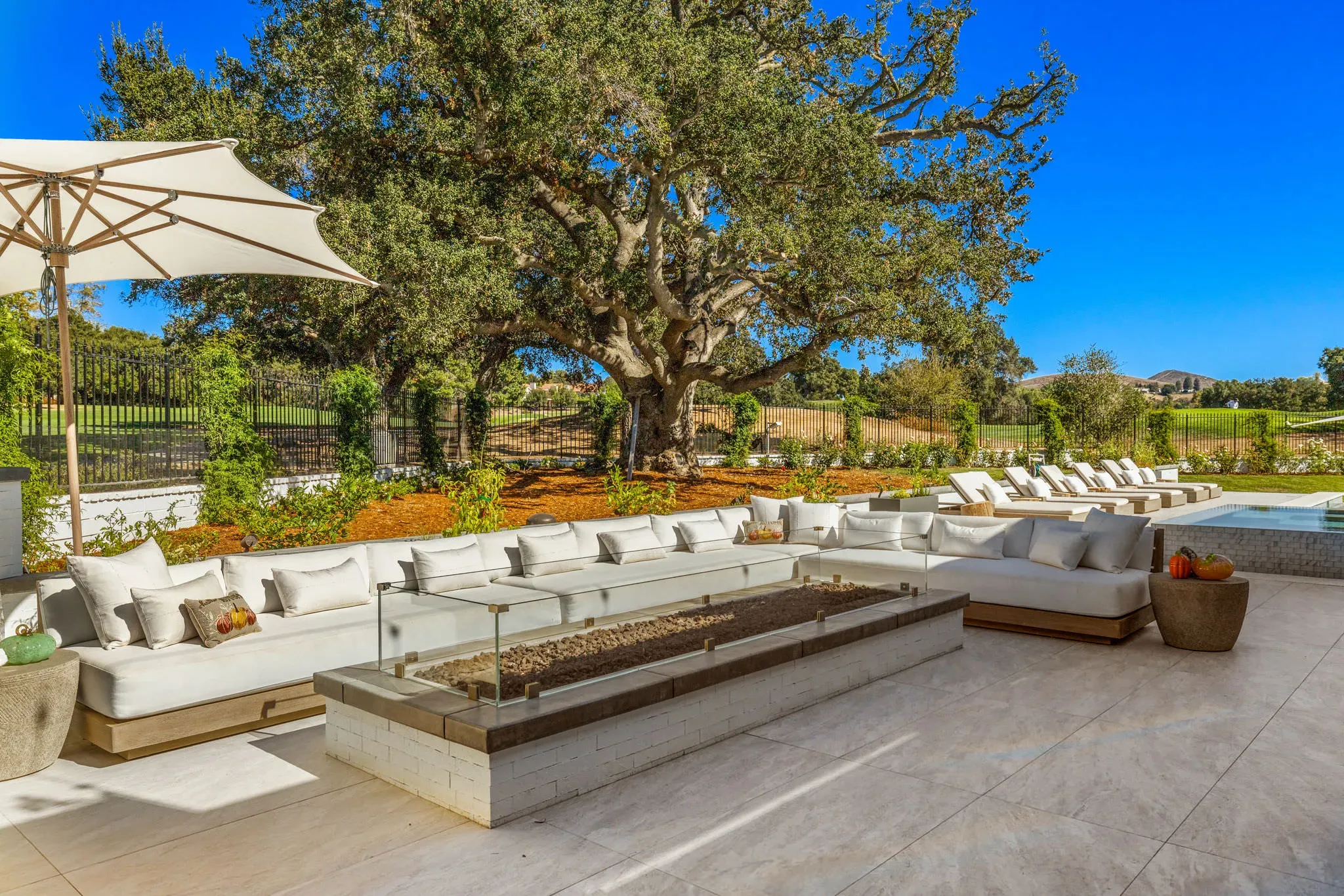 Outdoor living area and pool beneath a mature oak in North Ranch