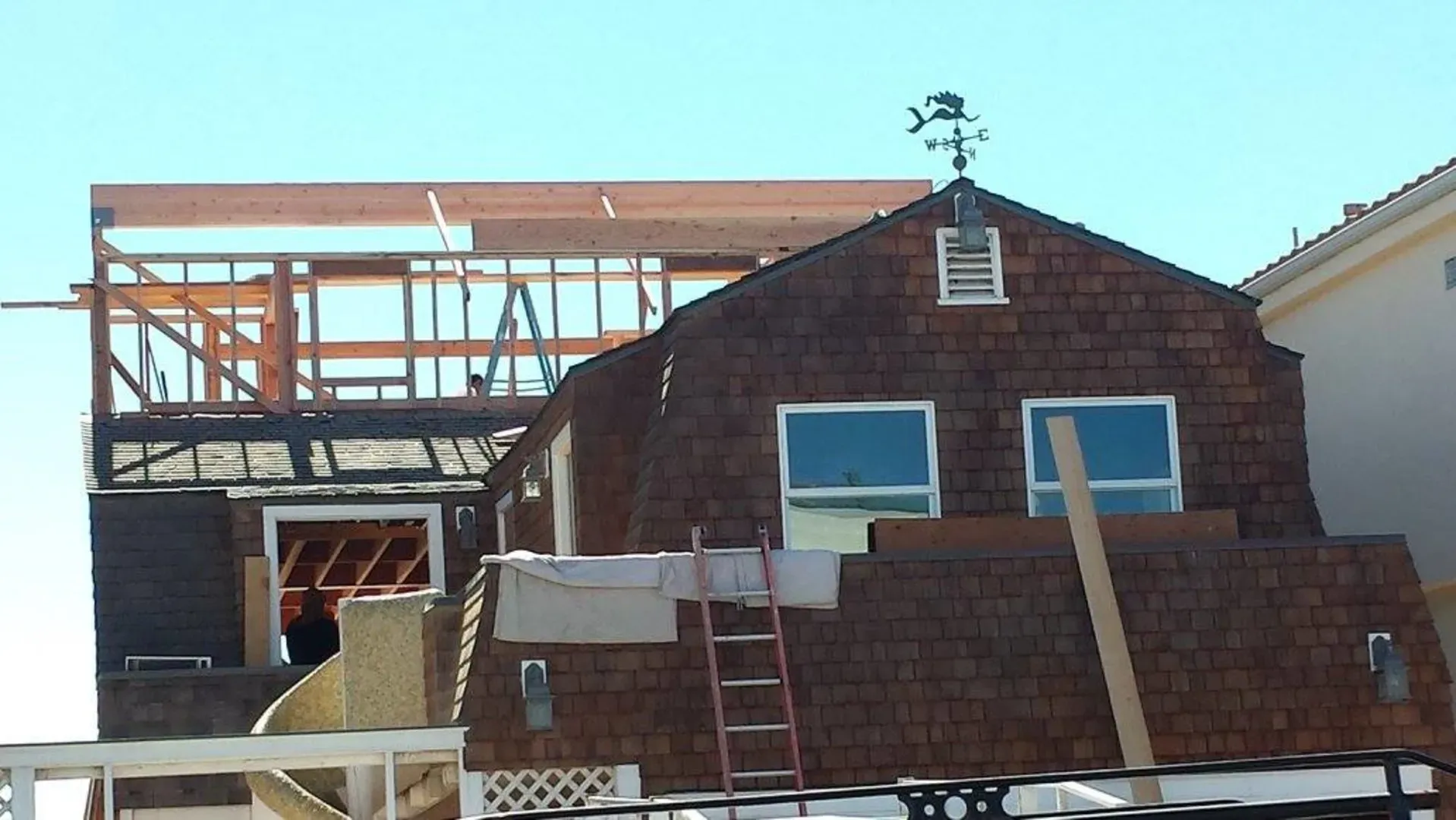 Roof framing for the new upper level, weathervane still in place