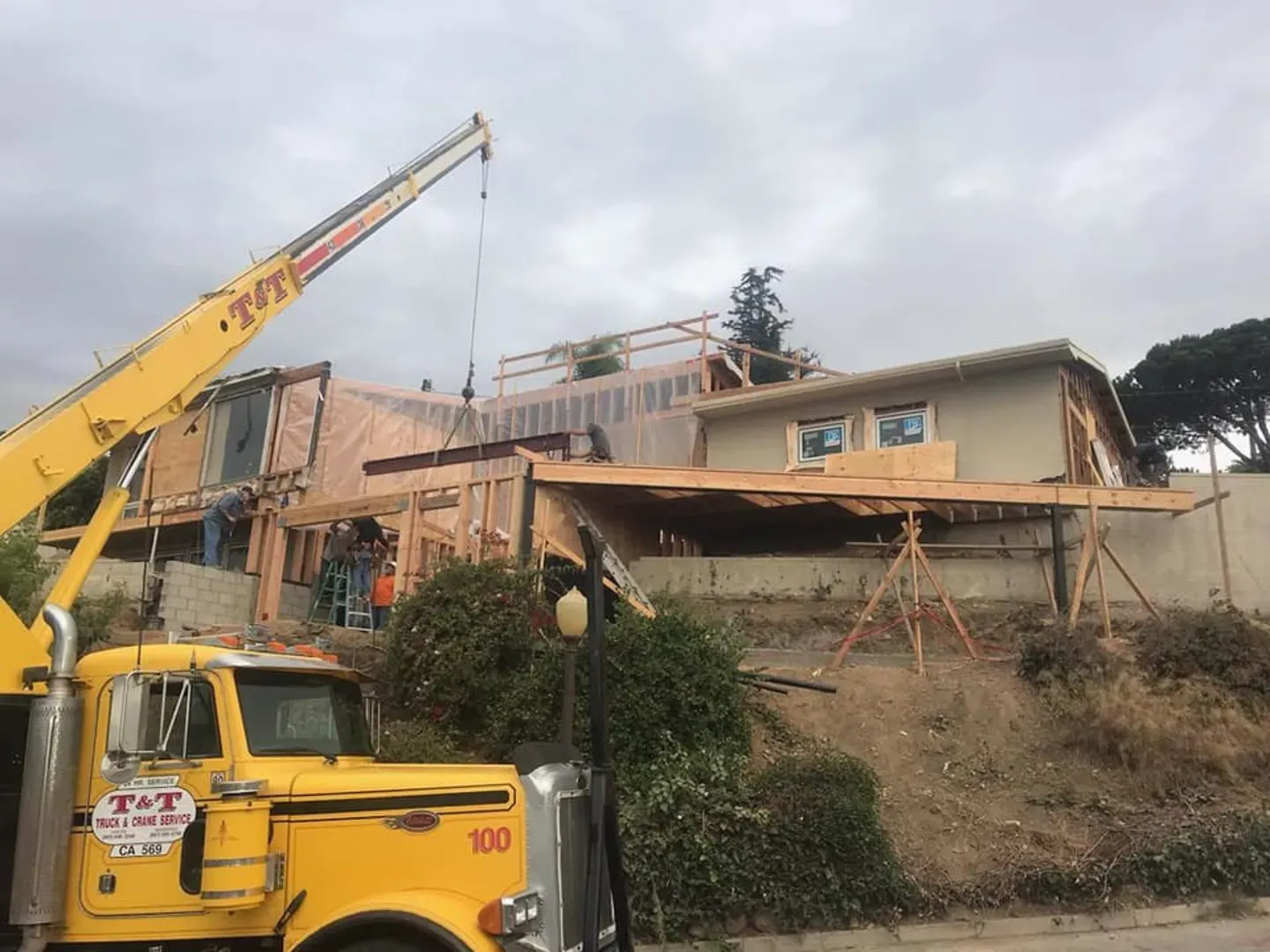 Crane lifting structural framing over the Sunset Lane house in Ventura