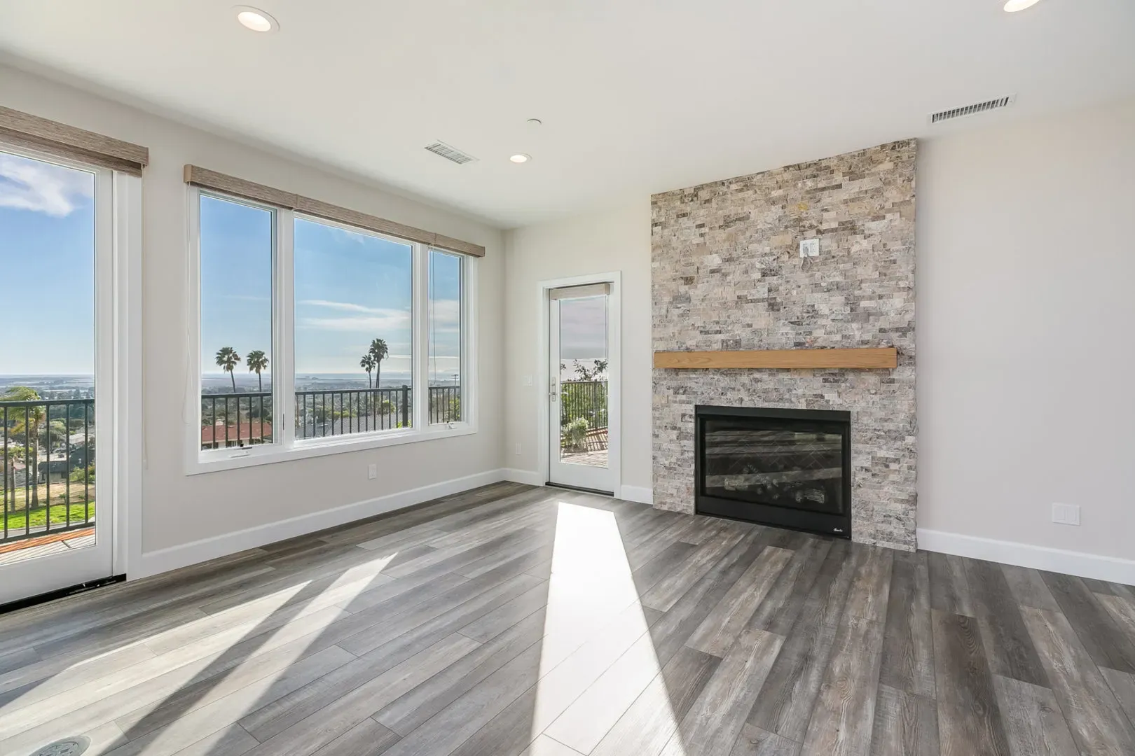Living room with stacked-stone fireplace and view windows