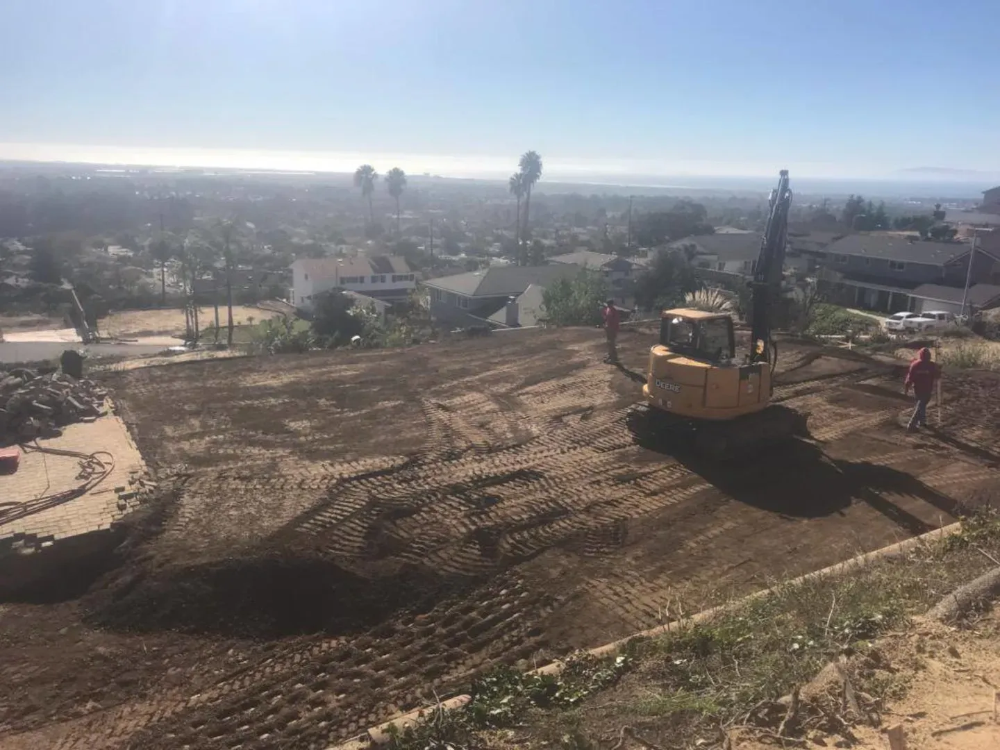 Excavator regrading the burned hillside lot in Ventura